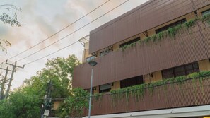 A multi-story building with a modern design, featuring vertical wooden slats and green plants on the exterior. - Tedu Hotel (Canggu)