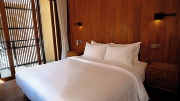 Ein Hotelzimmer mit einem großen Bett, einem Holzkopfende, einem Nachttisch und einer Wandleuchte.