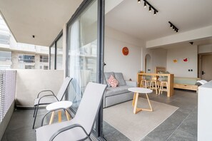 A modern living room with a sofa, chairs, a small table, and a dining area with stools. - Girasol - Loft Aranza c-Balcón Condesa Views (Mexico City)