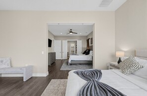 A bedroom with a bed, a nightstand, a dresser, a chair, and a ceiling fan. - Spacious 3BR/4Bed Austin Home Near Tesla, Samsung & Amazon, EV Charger (Austin)