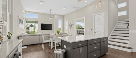 A modern kitchen with a central island, built-in cabinets, and pendant lighting.