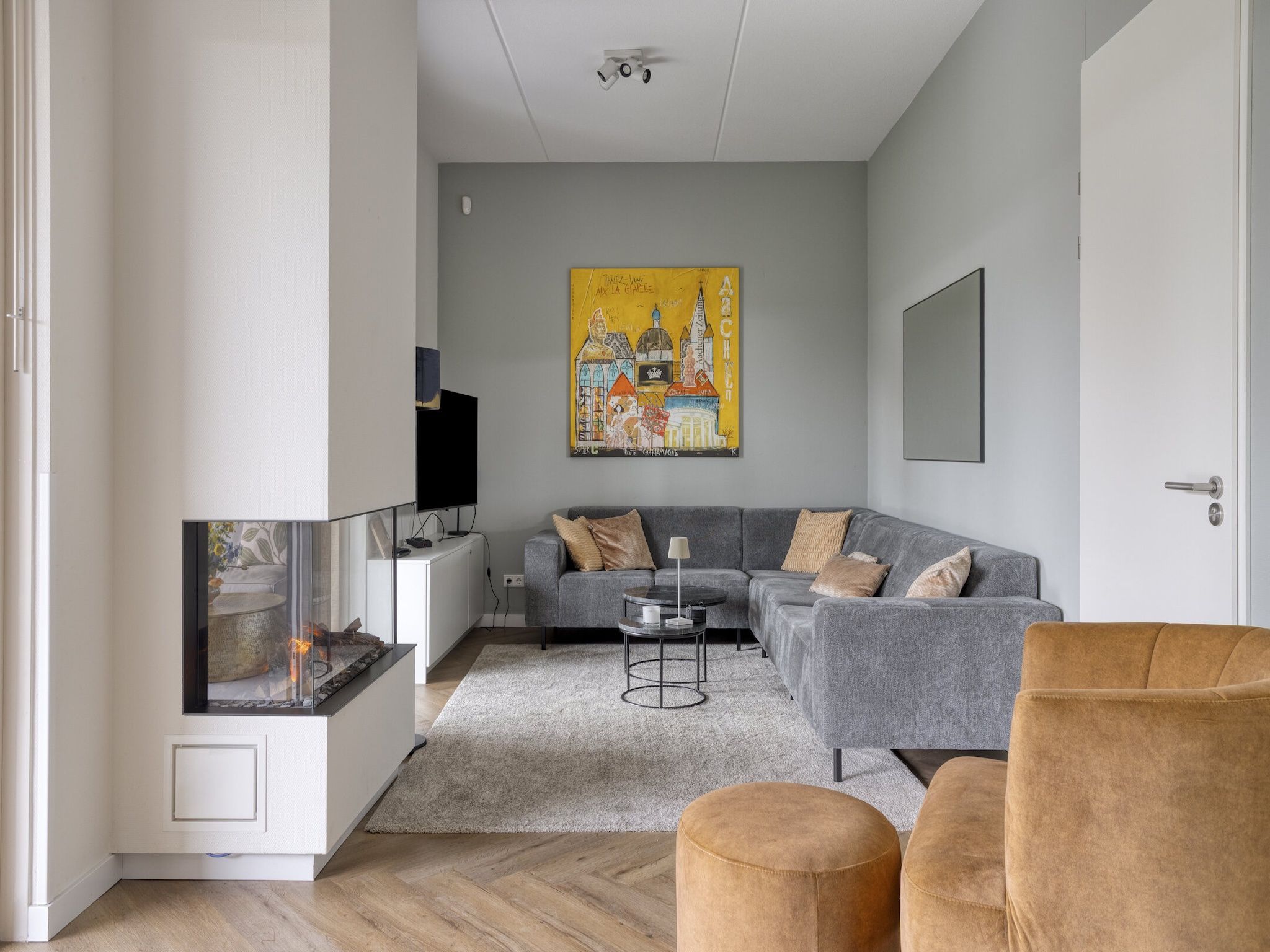 A modern living room with a grey sofa set, a coffee table, and a fireplace.