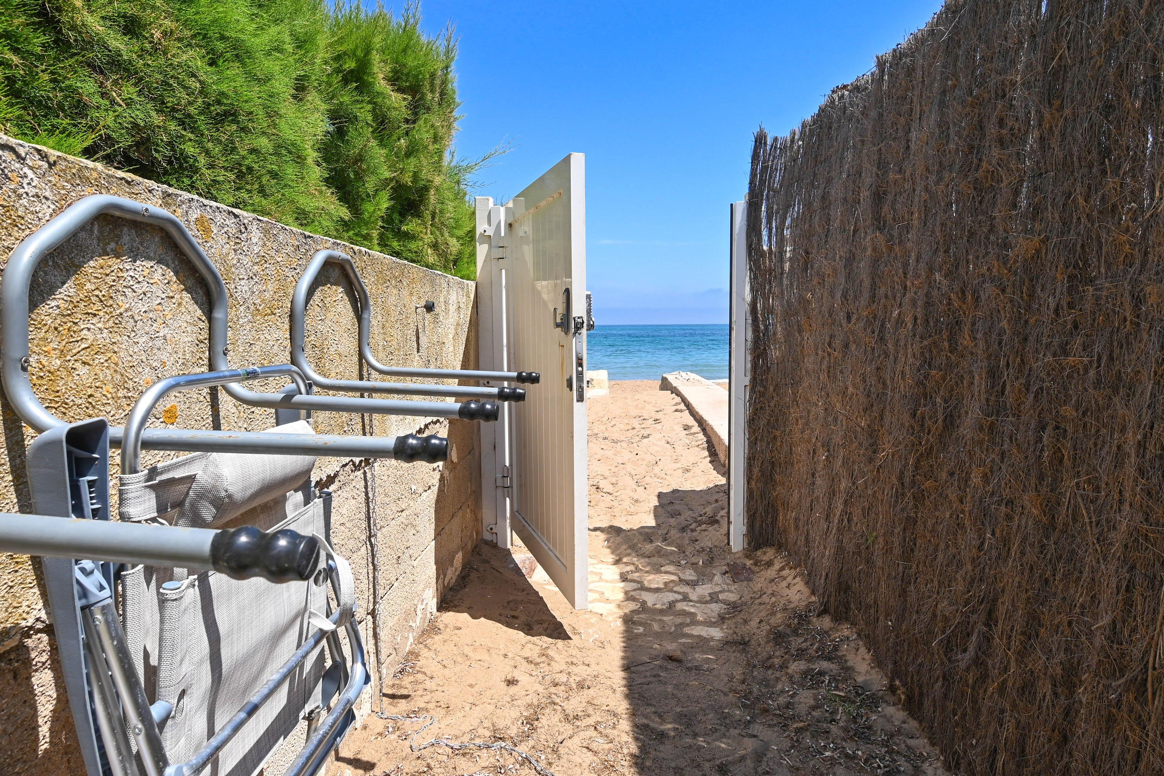 A metal gate leading to a beach with a clear view of the sea. - El Jabeque 4 pax - Denia, Costa Blanca (Denia)