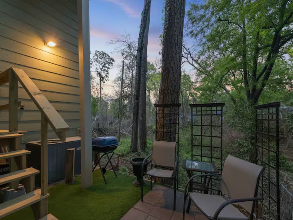 Un patio con mobiliario exterior, una parrilla y una terraza de madera.