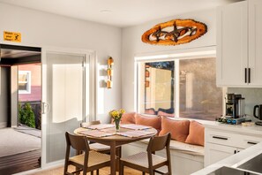 A modern kitchen with white cabinets, a coffee machine, and a window with blinds. - Private Softub, Walk to Junction - 2BR + Den, King Bed (Seattle)