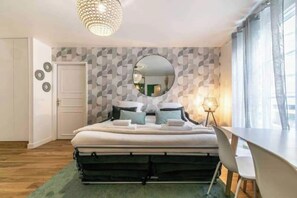 A bedroom with a bed, a desk, a chair, a mirror, and a patterned wall. - Beautiful apt -2br/6p- Montreuil - Near Paris (Montreuil)
