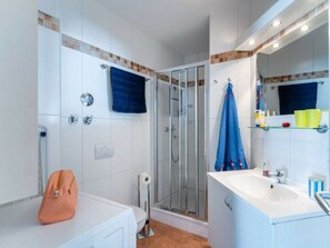 A modern bathroom with a glass shower enclosure, a white sink, and a mirror above the sink. - Holiday Apartment With 2 Bedrooms (Grossenbrode)