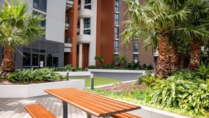 Een terras met banken en palmbomen.
