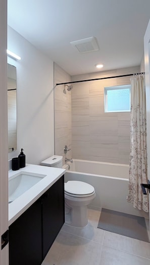 Et moderne badeværelse med toilet, vask og badekar.