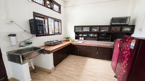 Une cuisine compacte équipée d’un évier, d’une cuisinière, d’un four à micro-ondes et d’un réfrigérateur.