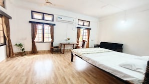 A room with a bed, a desk, a chair, and a potted plant. - Vandara Oasis | King Size Bed AC Room (Guwahati)