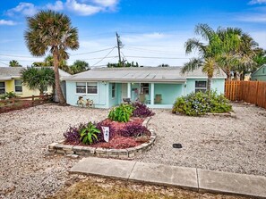 A residential property with a single-story house, a gravel driveway, and a landscaped garden with various plants. - Ormond Beach House Near the Shore (Ormond Beach)