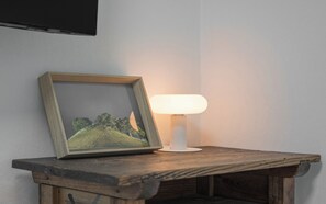 A framed picture on a wooden table with a white lamp beside it. - Gyeongju Hwangnam Inn Mini Hotel (Gyeongju)