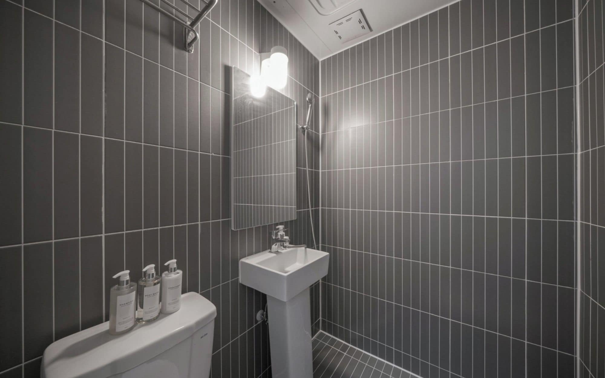 A bathroom with a toilet, sink, and shower.