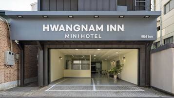 L'ingresso del Mini Hotel Hwangnam Inn, con una porta in vetro trasparente e un'insegna sopra.