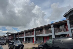 A multi-story building with balconies and a parking area. - Blue Way Inn & Suites Houston - Katy/Rosenberg (Rosenberg)