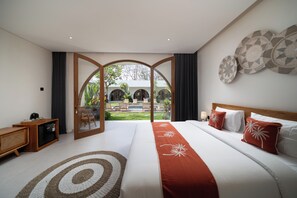 Een slaapkamer met een groot bed, uitzicht op een zwembad en een terras, en een houten kast.