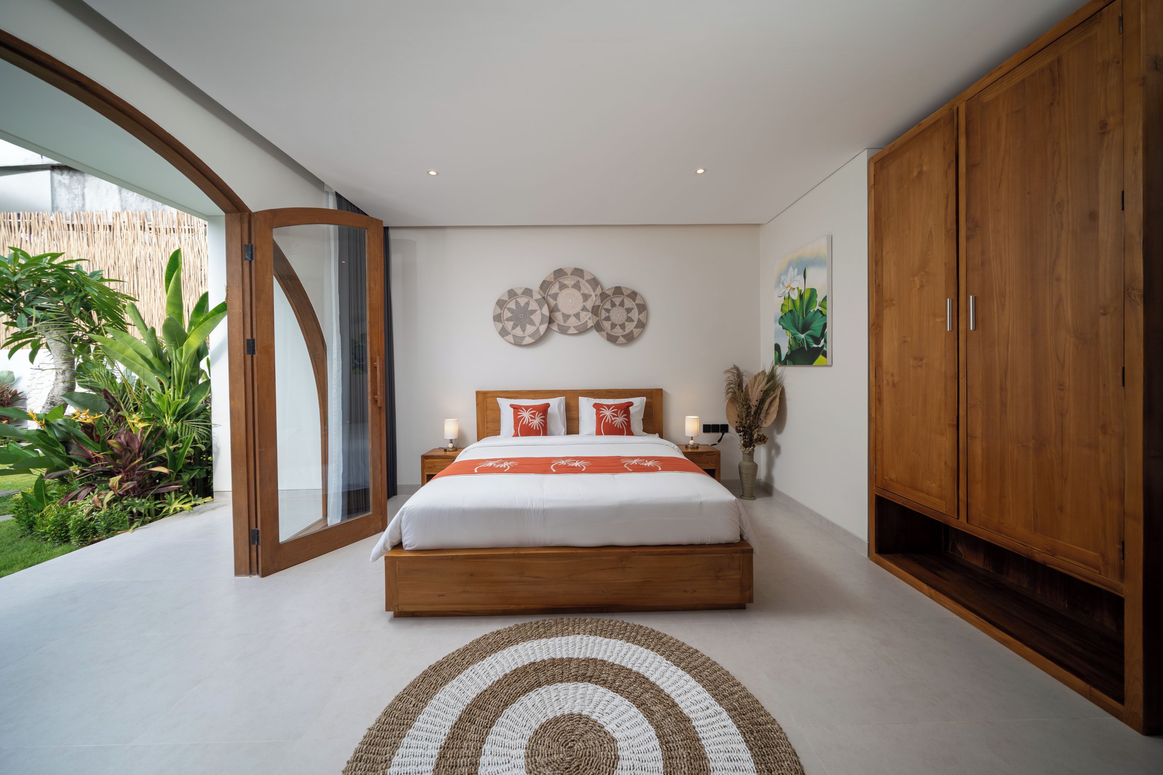 Un dormitorio con una cama grande, un armario de madera y vistas a zonas verdes.