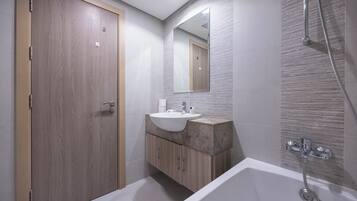 A modern bathroom with a wooden door, a sink with a marble countertop, a large mirror, and a walk-in shower.