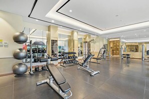 A modern gym with various exercise equipment, including weight machines, free weights, and cardio machines. - Chiro by Kozystay - Tanjung Barat (Jakarta)