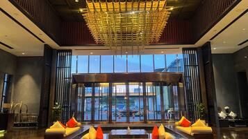 A lobby with a reception desk, seating area, and a large window offering a view of the street.