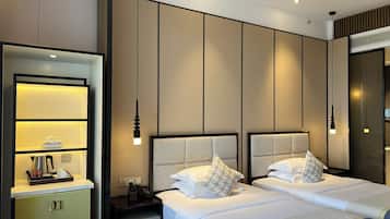 Habitación de hotel con cama, mesitas de noche, un espejo y estante en la pared.