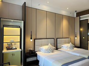 A hotel room with a bed, bedside tables, a nightstand, a mirror, and a wall-mounted shelf.
