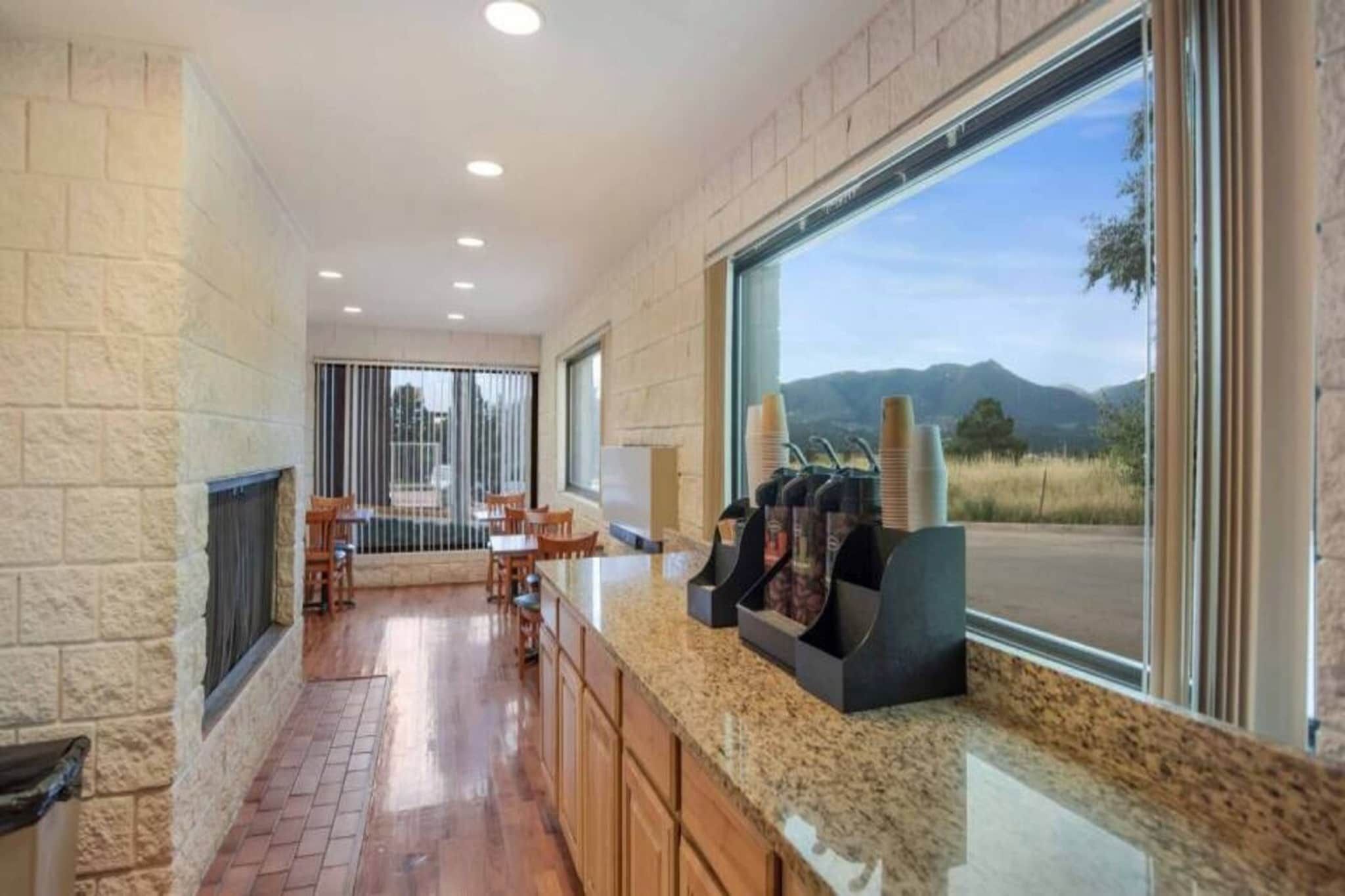 A kitchen with a granite countertop, wooden cabinets, a built-in stove, and a window with a mountain view.