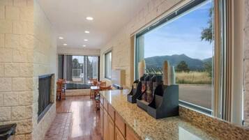 A kitchen with a granite countertop, wooden cabinets, a built-in stove, and a window with a mountain view.