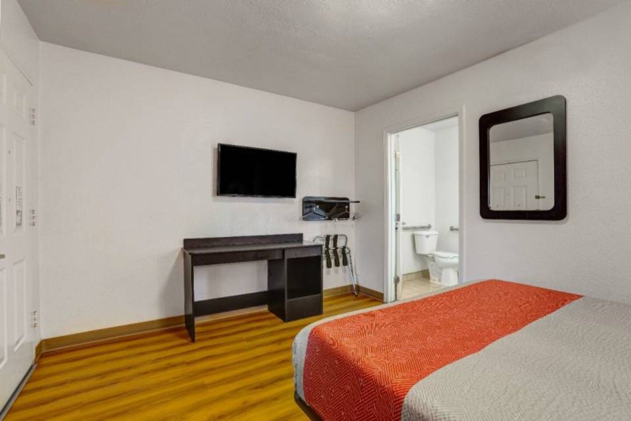 Une chambre d’hôtel équipée d’un lit, d’un bureau, d’une télévision et d’une salle de bain.