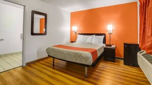 A hotel room with a bed, bedside tables, a mirror, and a heater. - 1 Queen Bed | Non-Smoking, Micfridge (Marysville)