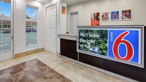 A hotel lobby with a reception desk, a large digital sign, and a view of the parking lot. - 2 Full Beds | Non-Smoking, Micfridge (Marysville)