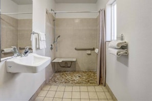 Un baño con ducha, lavamanos y perchero.