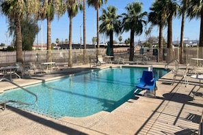 A clear pool with a metal ladder, surrounded by palm trees and a fence. - 2 Queen Beds | Non-Smoking (Phoenix)