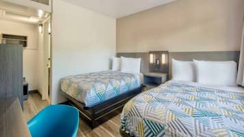 Una habitación de hotel con dos camas, un escritorio y una silla.