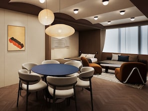 A modern hotel room with a round dining table, comfortable seating, a sofa, and a large window providing a view. - illi Vau Hamamatsucho (Minato-ku)