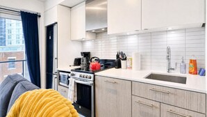Una cocina moderna con armarios blancos, una estufa y un lavamanos.