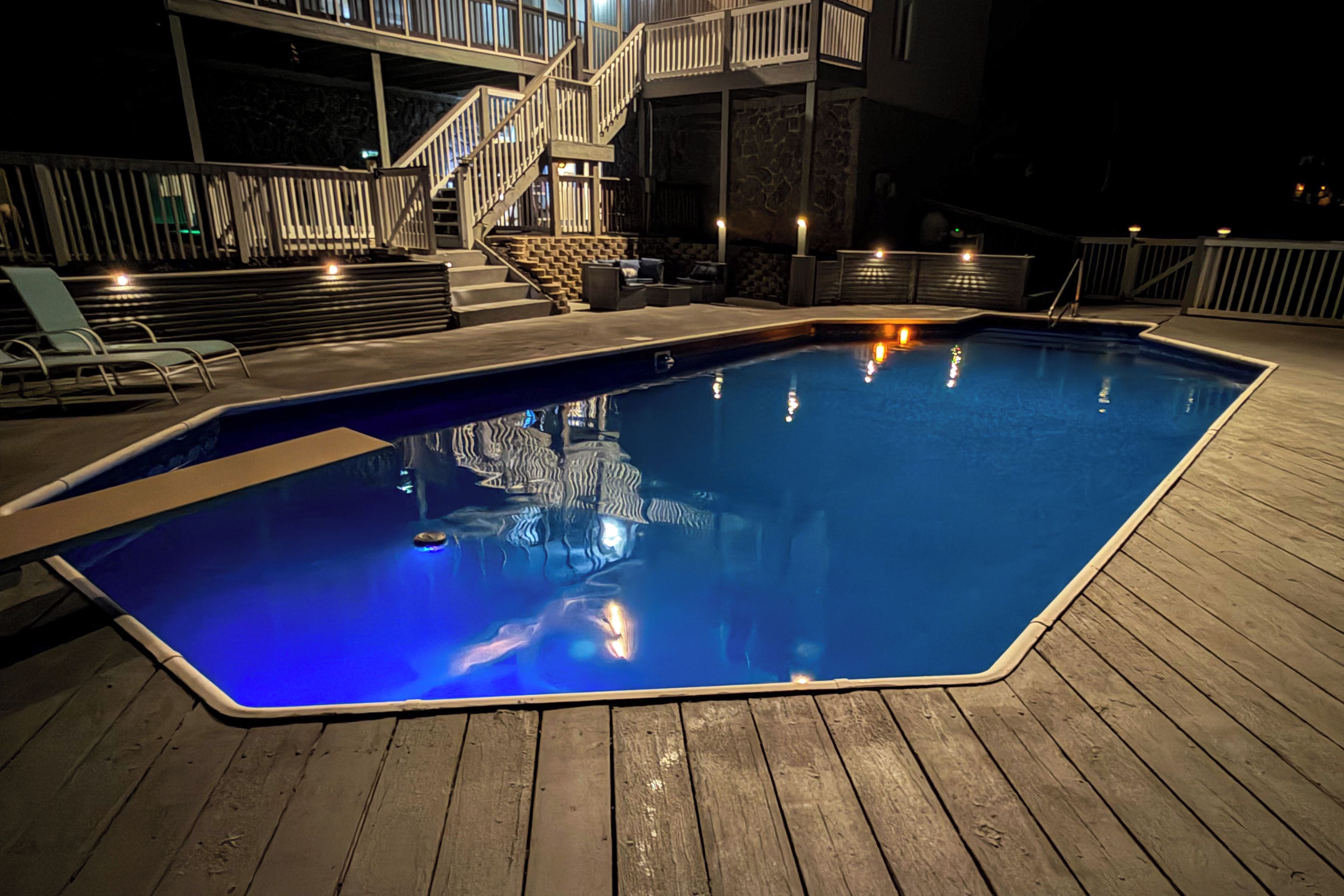 Una piscina con cubierta de madera, rodeada por un muro de piedra y una escalera que lleva a un nivel superior.