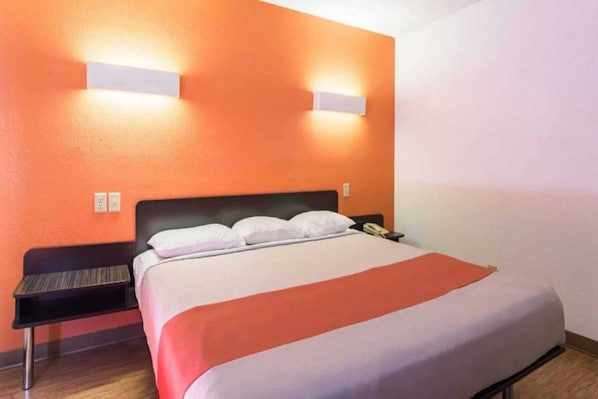 A hotel room with a bed, a nightstand, and a telephone.