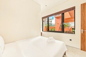 A hotel room with a bed, a window, and a view of the outside. - The RED Signature 5br sunset (Đà Nẵng)