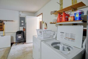 A laundry area with a Kenmore washer and dryer, a white plastic basket, and a shelf with cleaning supplies. - 8 Mi to New Smyrna Beach! Home w/ Poolside Oasis (Edgewater)