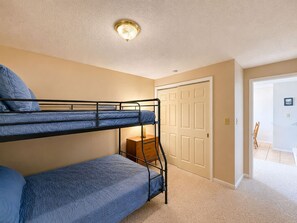 A bunk bed room with a door and a small table. - Waters Edge Lakefront Escape (Gravois Mills)