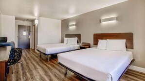 A hotel room with two beds, a desk, and a chair. - 2 Queen Beds | Non-Smoking (Hesperia)