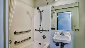 Ein Badezimmer mit Badewanne, Dusche, Waschbecken und Spiegel.