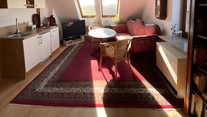 A spacious loft with a kitchen, dining area, and seating space. - Apartment 'Ferienwohnung in Upflamör' with Shared Garden, Balcony and Wi-Fi (Zwiefalten)