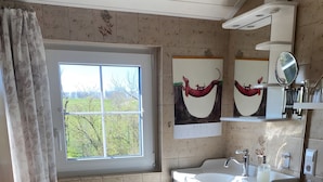 A bathroom with a window, a sink, a toilet, and a mirror. - Apartment 'Ferienwohnung in Upflamör' with Shared Garden, Balcony and Wi-Fi (Zwiefalten)