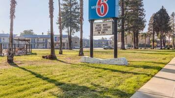 A motel sign with a large number '6' and a signboard below advertising free WiFi, a micro bridge, 3 HBO ESPN, and in RMS.