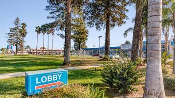 A lobby area with a sign, surrounded by trees and a clear sky.