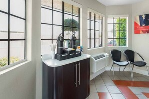A hotel room with a kitchenette, a seating area with chairs, large windows, and a poster on the wall. - Sunny Queen Bed Room|Pool|Free Wifi (Merced)