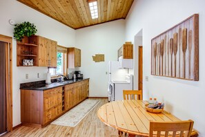 A kitchen with wooden cabinets, a dining table, and a refrigerator. - Hike, Paddle & Relax: Cabin By Cle Elum Lake (Ronald)